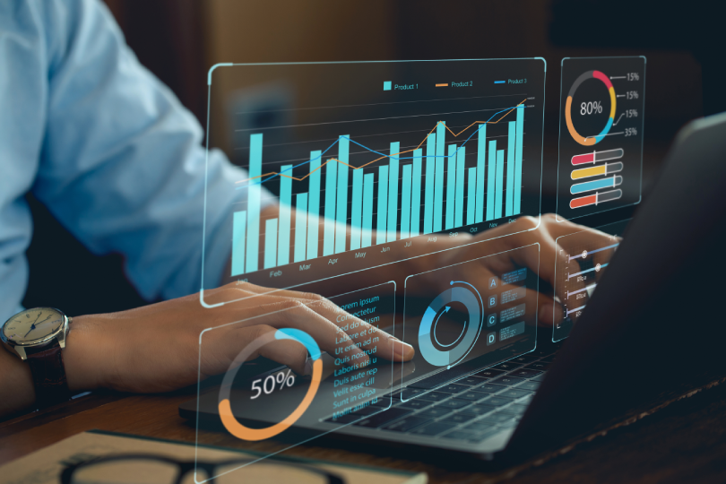 Uma pessoa trabalhando em um laptop com um gráfico na tela que indica a adoção de Business Intelligence.