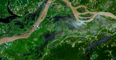 Uma vista aérea de um rio e de uma terra, representando sensoriamento remoto.