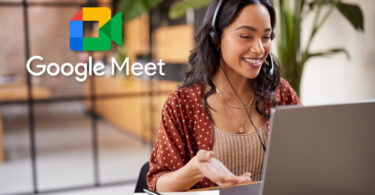Uma mulher sentada em frente a um laptop com o logo do Google Meet ao lado.