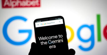 Gemini IA - Uma pessoa segurando um celular em frente ao logotipo do Google.